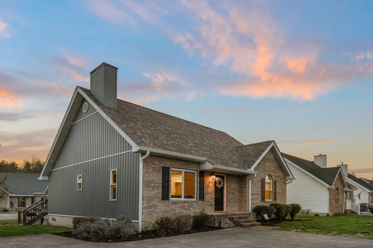 A broad view of the front porch with large windows, a chimney, and a landscaped garden. The porch appears ideal for relaxing after a day of exploring, and the garden offers a sense of tranquility and space for pets to roam (leashed).